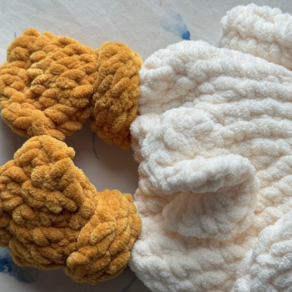 Detailed shot of the back of a crocheted goose snuggled to show the ruffled tail feather and knotted feet.