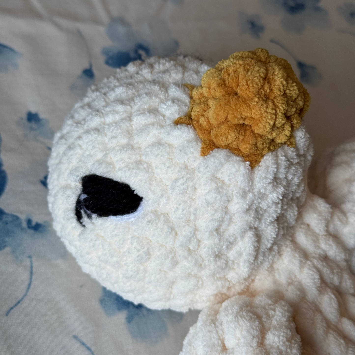 Detailed shot of embroidered eyes of goose snuggler.